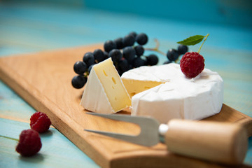 cheese camembert with raspberries and grapes on