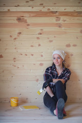 Woman with brush repair in a wooden house