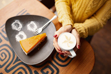 Slice of delicious carrot cheesecake and latte cup