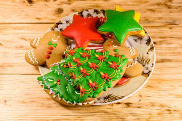 Plate with different christmas gingerbread cookies on wooden table