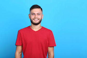 Young man in red t-shirt on blue background