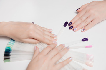 Obraz na płótnie Canvas Velvety well-groomed female hands with light by sudovym nail Polish craftsmen and purple manicure client