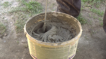 Mixing of concrete in a bucket at a construction site