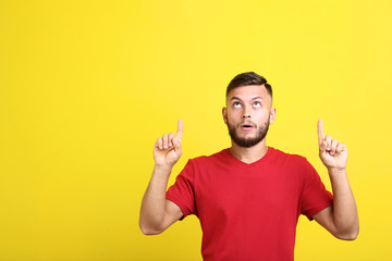 Young man in red t-shirt on yellow background