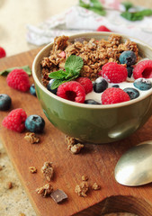 Healthy breakfast. Granola, muesli with yogurt and fresh berries in a bowl on wooden background.