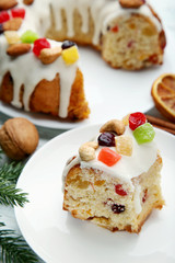 Slice of bundt cake with candied fruit and cashew in white plate