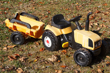 Tracteur à pédales et remorque pour enfant dans un jardin