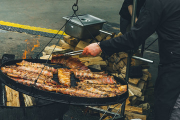 Grilled ribs. Street food. Fried meat on grill. Golden roasting