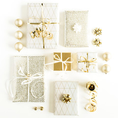 Gift boxes with bows and gold decorations on white background. New Year, Christmas festive flat lay, top view composition.