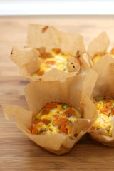 Small omelettes with butternut squash, feta cheese and peas, wrapped in parchment paper. Picnic food. Selective focus.