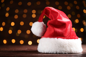 Obraz na płótnie Canvas Santa claus hat on bokeh lights background