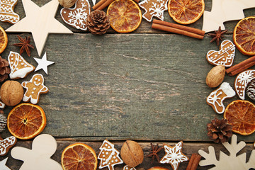 Christmas gingerbread cookies with dry oranges and walnuts on grey wooden table
