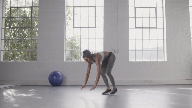 Woman doing burpee workout at fitness studio
