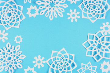 Paper snowflakes on blue background. Top view. Christmas decoration. Toned