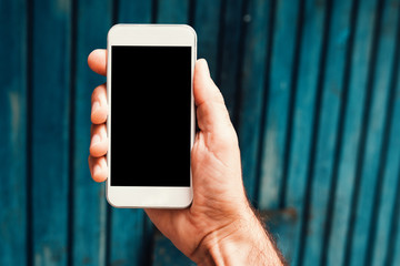 Hand with smartphone mock up screen in urban surrounding