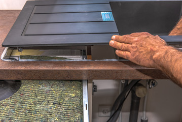 A furniture carpentA furniture carpenter insert a sink into a kitchen counter. Concept: craft and serviceer insert a sink into a kitchen counter. Concept: craft and service