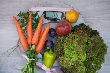 Dieting healthy eating slim down weight control concept. Closeup green broccoli with measuring tape on white scales