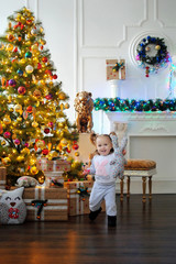 Ребенок ждет чуда в Новый год. С новым годом! Счастливого Рождества! Новогодняя елка с рождественскими игрушками. Девочка с подарками.
