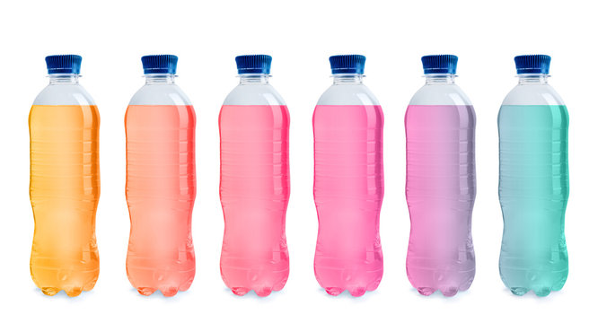 Set with different bottles of colorful drinks on white background