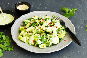 A fresh salad of green vegetables, dressed with yogurt.