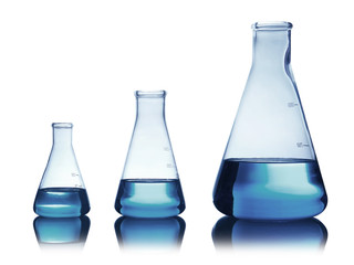 Conical flasks with liquid on table against color background. Laboratory analysis