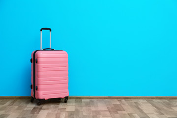 Packed suitcase near color wall with space for text