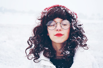 Young and pretty woman enjoying a snowy winter day
