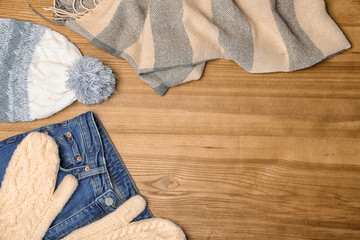 Stylish autumn outfit on wooden background, flat lay with space for text. Trendy warm clothes