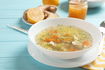 Bowl of fresh homemade soup to cure flu on wooden table