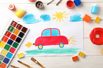 Flat lay composition with child's painting of car on table