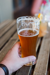 a man's hand holds a glass of beer closeup