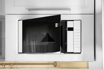 Open modern microwave oven built in kitchen furniture