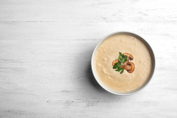 Bowl of fresh homemade mushroom soup on white background, top view