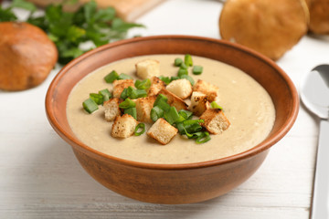 Bowl of fresh homemade mushroom soup on white background, top view