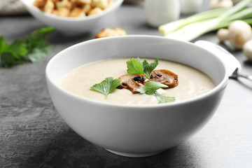 Bowl of fresh homemade mushroom soup on white background, top view