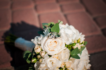 White wedding bouquet with white gold wedding rings
