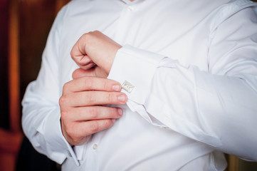 Groom holding hand on the cuff