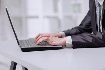 close up. businessman typing on laptop while sitting at table