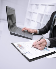 close up. businessman uses laptop to test financial graphics