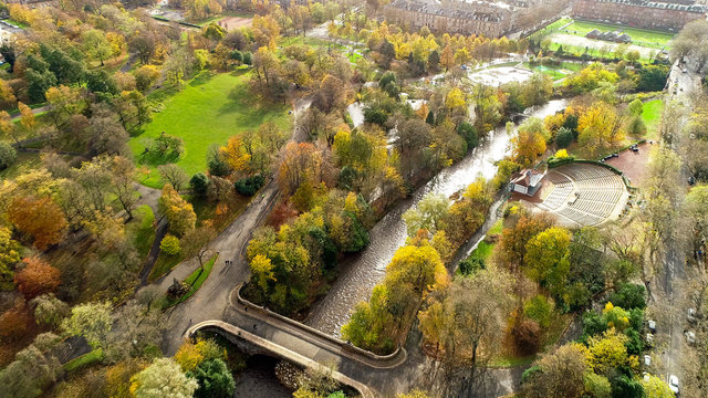Aerial image of the restored open air bandstand and amphitheatre in Kelvingrove Park, Glasgow, surrounded by autumn coloured woodland and the River Kelvin.