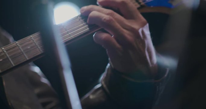 The guitarist's hand playing chords on the electric guitar