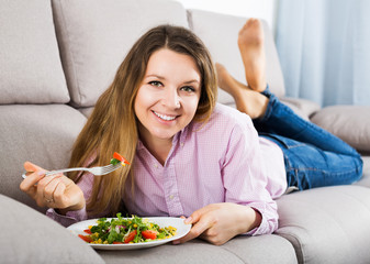 Obraz na płótnie Canvas Woman tasting fresh green salad