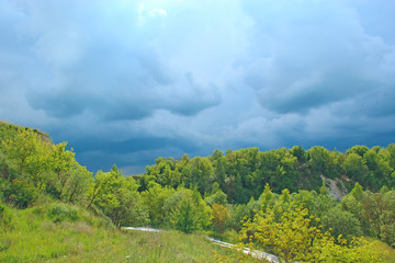 Landscape with thundercloud over green forest. Stormcloud above green vegetation