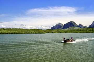 A motor boat is sailing along the bay in Thailand.