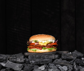 Black burger on charcoal