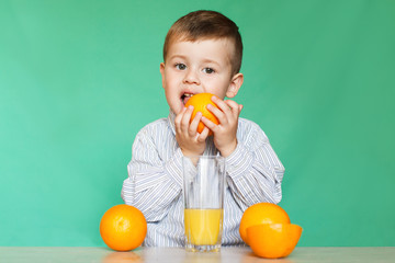 Little boy with oranges and juice.