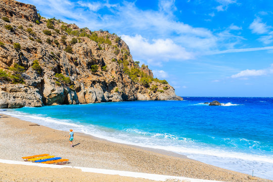 Young woman walking along beautiful Achata beach, Karpathos island, Greece