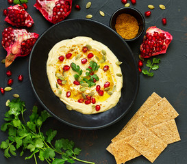Traditional hummus, with pomegranate and cereal loaves. selective focus.