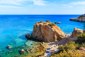 Walkway to beautiful bay with beach in Ammopi village on sea coast of Karpathos island, Greece