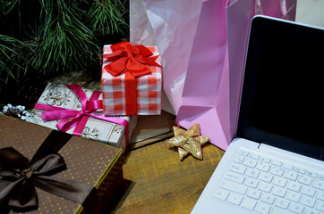 Cristmas background with office table with open laptop, gift boxes. Business holidays concept. Online shopping for Christmas presents. Christmas sales.